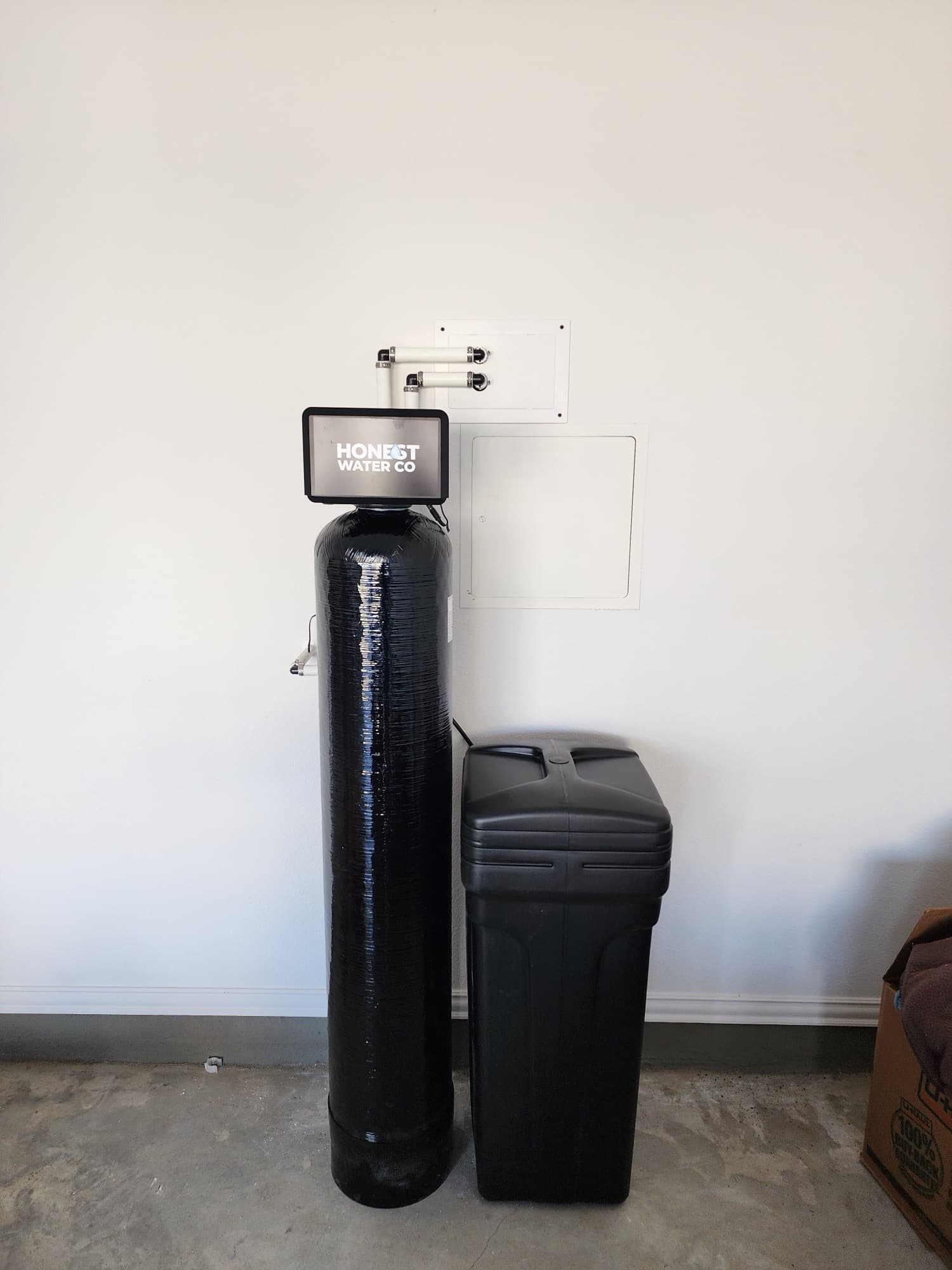Honest Water Co softener and brine tank on a garage floor with the bypass accessible